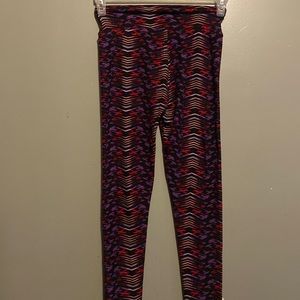 LulaRoe one size leggings black with purple/ red/ yellow pattern.